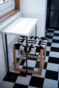 a white table and stool on a checkered floor at Lemon Tree Stay in Faro