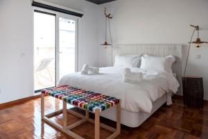 a bedroom with a large white bed with a wooden platform at Lemon Tree Stay in Faro