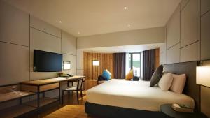 a hotel room with a bed and a desk at PARKROYAL Penang Resort in Batu Ferringhi