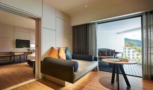a living room with a couch and a table at PARKROYAL Penang Resort in Batu Ferringhi