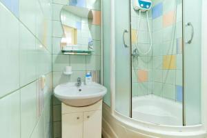 y baño con lavabo y ducha. en Home Hotel Apartments on Livoberezhna, en Kiev