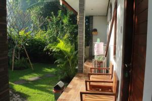 a balcony with a view of a garden at Twins Homestay in Canggu