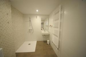 a white bathroom with a shower and a sink at Rio Sil Carballo in Carballo