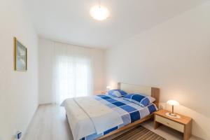 een slaapkamer met een groot bed met blauwe kussens bij Apartments Brekalo in Pakoštane