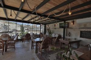 a dining room with tables and chairs and windows at Aren Cave Hotel And Art Gallery in Göreme