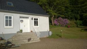 a white house with a white door and stairs at Moselundgaard B/B og Hestehotel in Engesvang