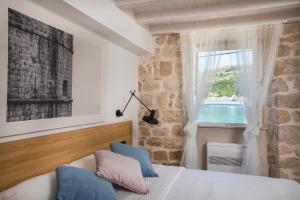 Un dormitorio con una cama con almohadas azules y una ventana. en Bova Luxury Rooms, en Dubrovnik 33 fotos más