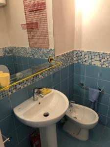 uma casa de banho com um lavatório, um WC e um espelho. em Mono Logge em Marciana Marina