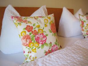 a pillow on a bed with flowers on it at Gästehaus Bergstüberl in Reit im Winkl