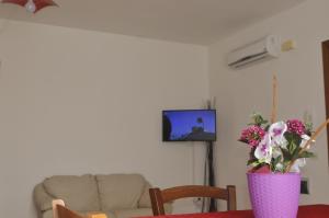 uma sala de estar com uma mesa com um vaso de flores em Torre Sances Holiday Apartament em Birgi Vecchi