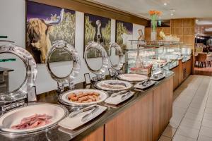 a buffet line with plates of food and mirrors at Glasgow Grosvenor Hotel in Glasgow