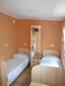 a bedroom with two beds and a mirror at Guesthouse on Benashvili in Tbilisi City