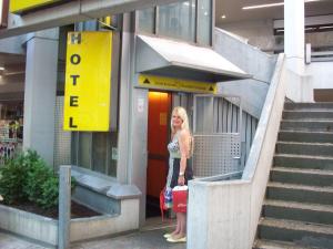 a woman is standing outside of a building at Gästehaus Kaiserpassage- Ihr Cityhostel in Karlsruhe