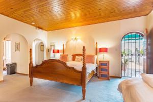 a bedroom with a bed and a wooden ceiling at Bay Tree Guest House in Pretoria