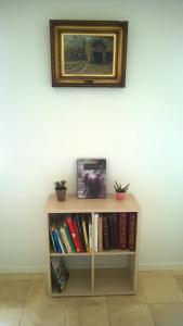 uma estante de livros com livros e uma foto na parede em Moselundgaard B/B og Hestehotel em Engesvang