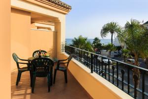 balcón con mesa, sillas y vistas al océano en Apartamentos Euromar Playa, en Torrox Costa