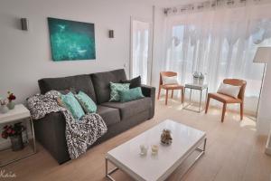 a living room with a couch and a table at Piso Paseo Marítimo in Benalmádena