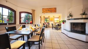 a restaurant with tables and chairs and a fireplace at Lokal Genial Pension & Restaurant in Beelitz