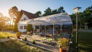a house with tables and chairs under a tent at Lokal Genial Pension & Restaurant in Beelitz