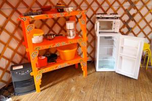 an orange shelf in a toy yurt with a refrigerator at Camping Kerlaudy Mer et Yourtes in Plouénan