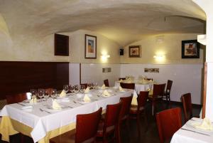 Un comedor con mesas y sillas con mantel blanco. en Hotel Gema, en Almadén