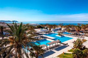 una vista aérea de un complejo con 2 piscinas y palmeras en Barceló Cabo de Gata en Retamar