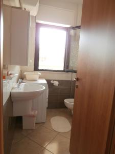 ロゼート・デッリ・アブルッツィにあるDonizetti Apartment 1のバスルーム(洗面台、トイレ付)、窓が備わります。