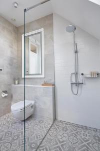 uma casa de banho com um WC e uma cabina de duche em vidro. em Siedlisko 518 - luksusowa Willa - Wzgórza Dylewskie em Glaznoty