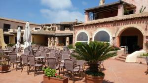 an outdoor patio with chairs and tables and umbrellas at Casa a La Marmorata in Santa Teresa Gallura