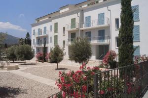 a large white building with flowers in front of it at Résidence Villa Tyrrenia in Macinaggio