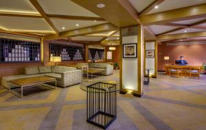 a lobby with couches and tables and a man sitting at a table at Sterling Manali in Manāli