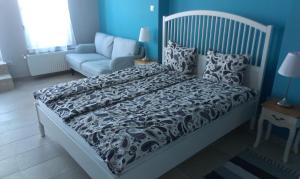 a bed with a black and white comforter and a couch at Budanest Apartments in Budapest