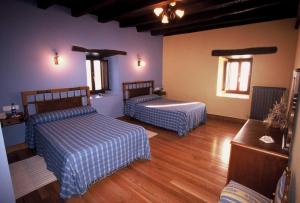 two beds in a room with wooden floors at Casa Rural Bentazar in Elosu