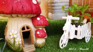 uma pequena casa de cogumelos com uma bicicleta ao lado em House 22 em Kaohsiung