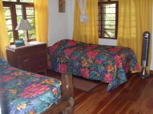 a bedroom with two beds and a table with a lamp at Forres Park Nature Retreat in Mavis Bank