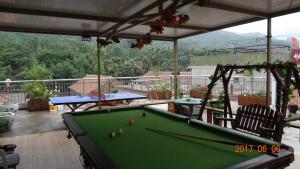 a pool table on top of a patio with awning at Huangyaguan Great Wall Li Bo Home Hotel in Jixian