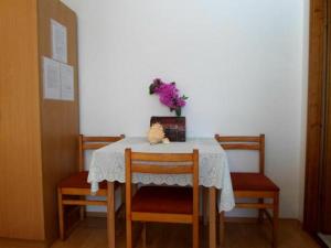 einen Tisch mit zwei Stühlen und eine Vase mit Blumen darauf in der Unterkunft Nice Studio apartment for 2 in Dubrovnik