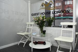 a table with a chair and a laptop on it at Guest House London in London