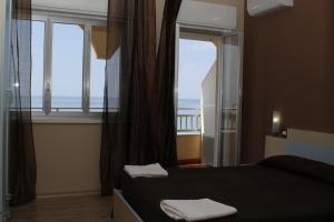a bedroom with a bed and a large window at Hotel Residence Paguro in Siculiana Marina