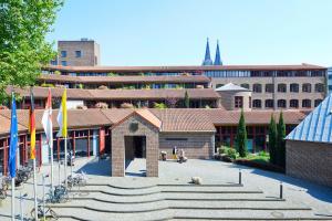 un groupe de bâtiments arborant des drapeaux dans une cour dans l'établissement Maternushaus, à Cologne