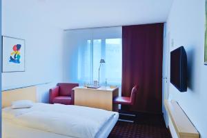 a hotel room with a bed and a desk and chair at Maternushaus in Cologne