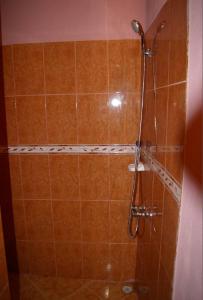 a shower with a shower head in a bathroom at Auberge Des Jardins du Dades in Boumalne
