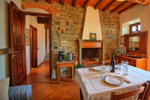 a kitchen with a table and a stone wall at Villa Panzalla by PosarelliVillas in Santo Stefano A Tizzano