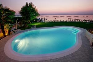 a large swimming pool with a view of the ocean at Hotel La Rondine in Sirmione