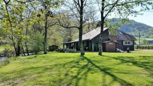 a house on a grassy yard with a tree shadow at Le gite des Mousquetaires in Lanne