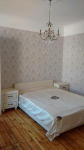 a bedroom with a bed and a chandelier at Sunshine apartment in Liepāja