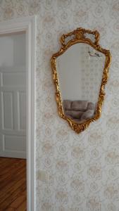 złote lustro wiszące na ścianie w pokoju w obiekcie Sunshine apartment w mieście Lipawa