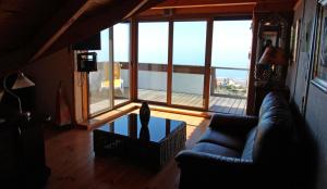 uma sala de estar com um sofá e uma mesa de vidro em ViVaTenerife - Retreat in nature, SPA and wellness em Tejina de Isora