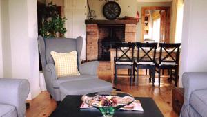 sala de estar con mesa, sillas y chimenea en The Watersedge Cottage en Castlegregory