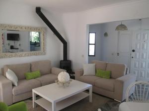 a living room with two couches and a table at Casa Vila Verde in Quarteira